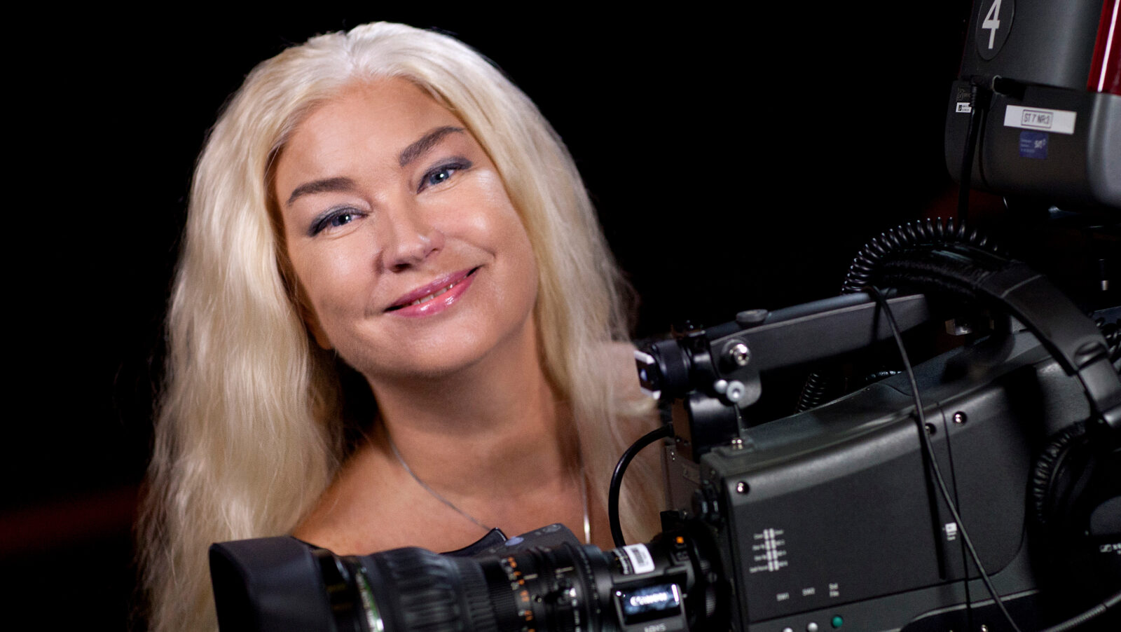 Porträtt på Eva Beckman bakom en tv-kamera.