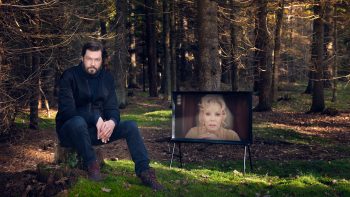 Kjell Häglund i skogen med en TV.