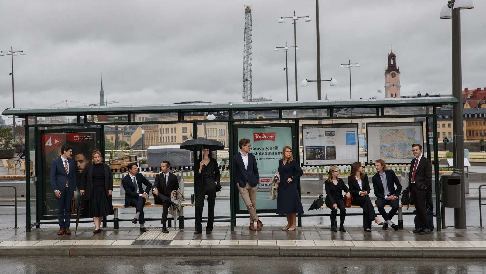 Centrum för rättvisas personal står i en busskur i Stockholm.