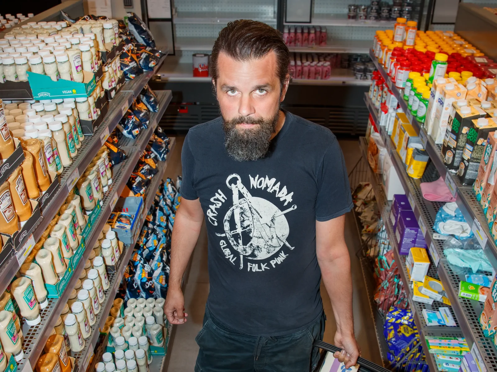 Andreas Jakobsson står i en gång mellan två hyllor i en av Matmissionens butiker.