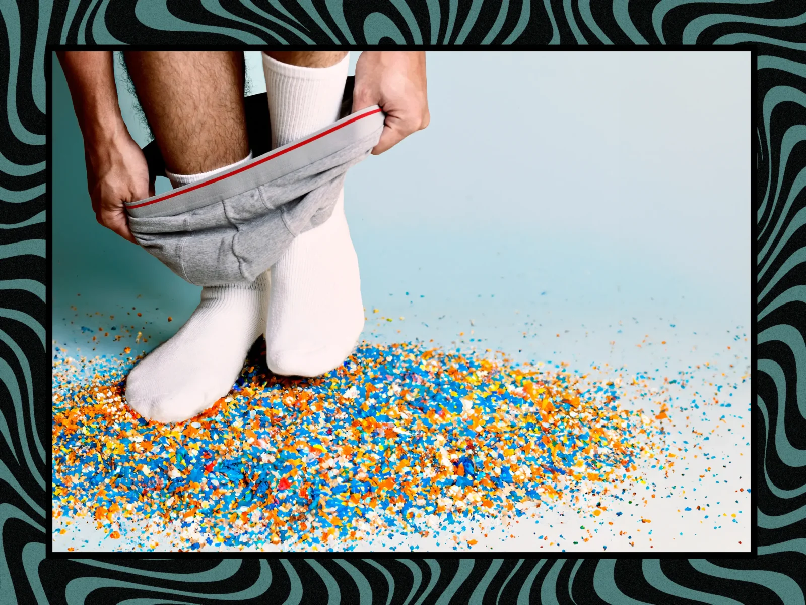 Bild på en man som tar på sina kalsonger, står på en hög av plastpartiklar, för att visualisera mikroplast i testiklar.
